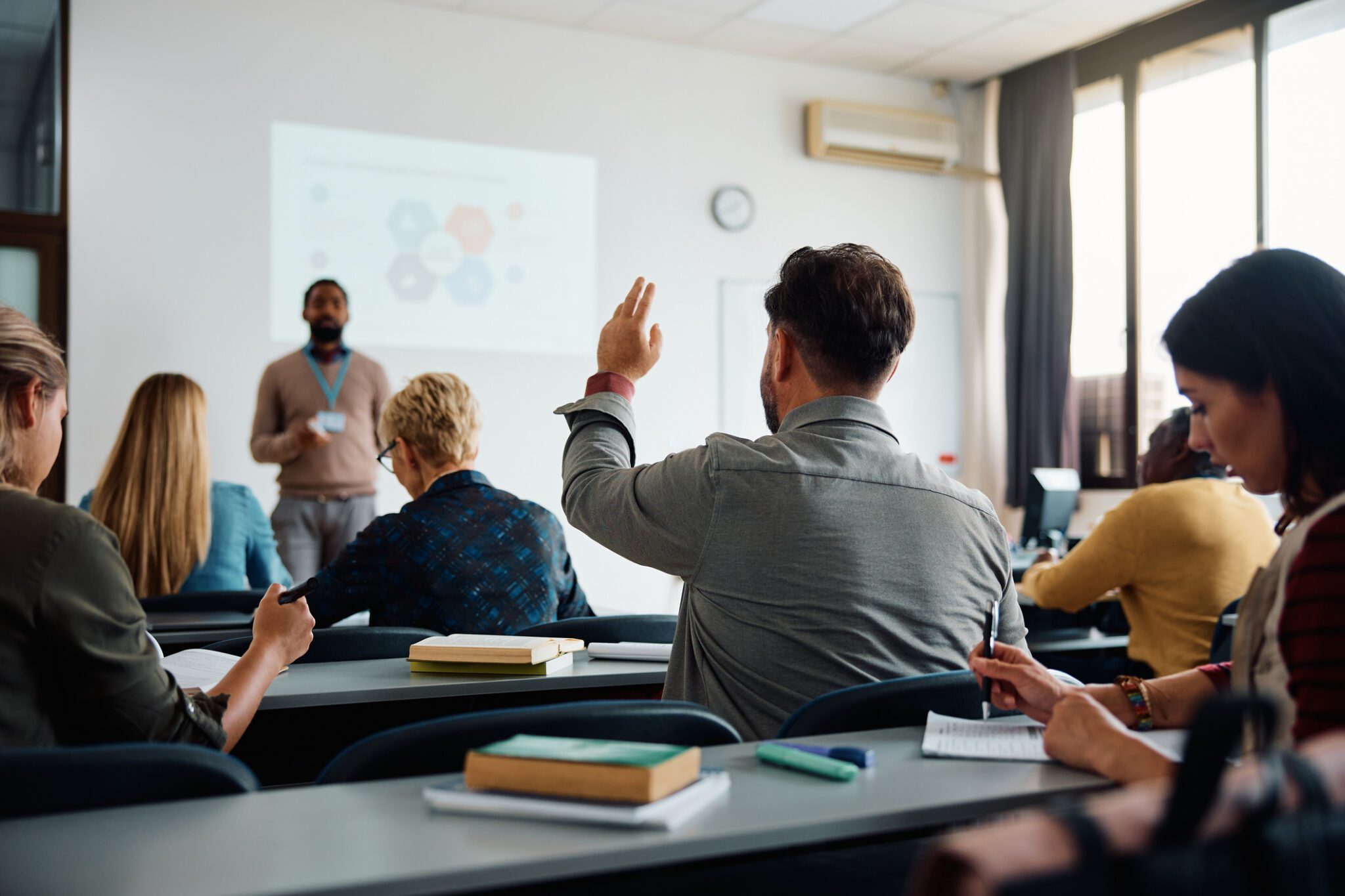 Student raising hand in lecture