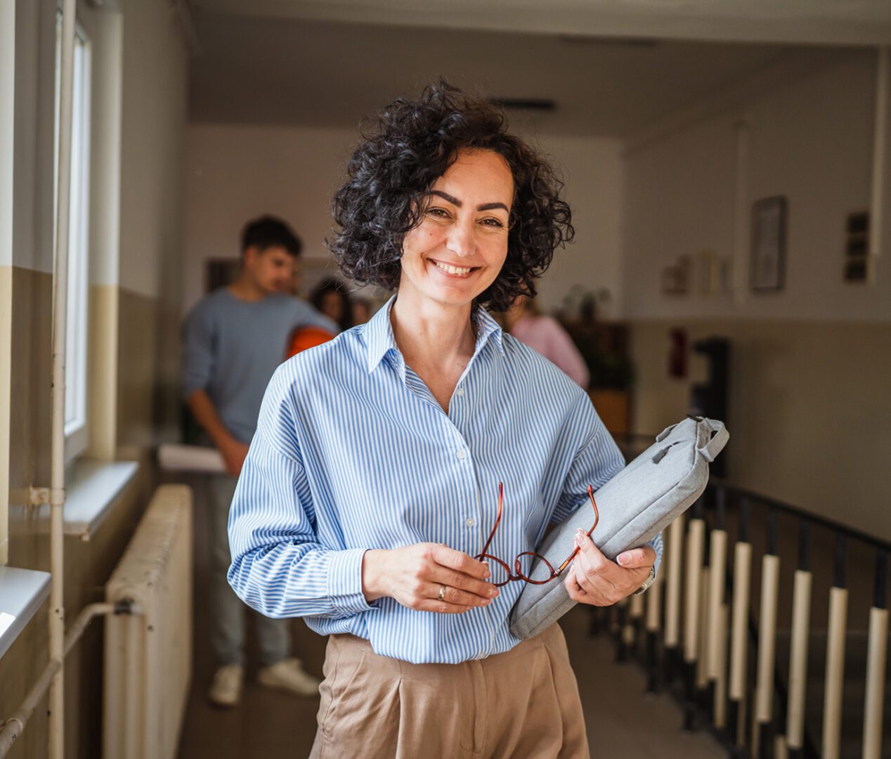 Confident woman in hallway with glasses