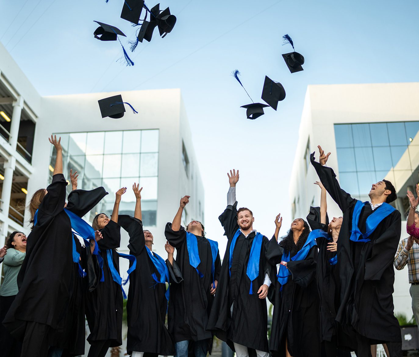 Joyful graduates throwing hats in the air