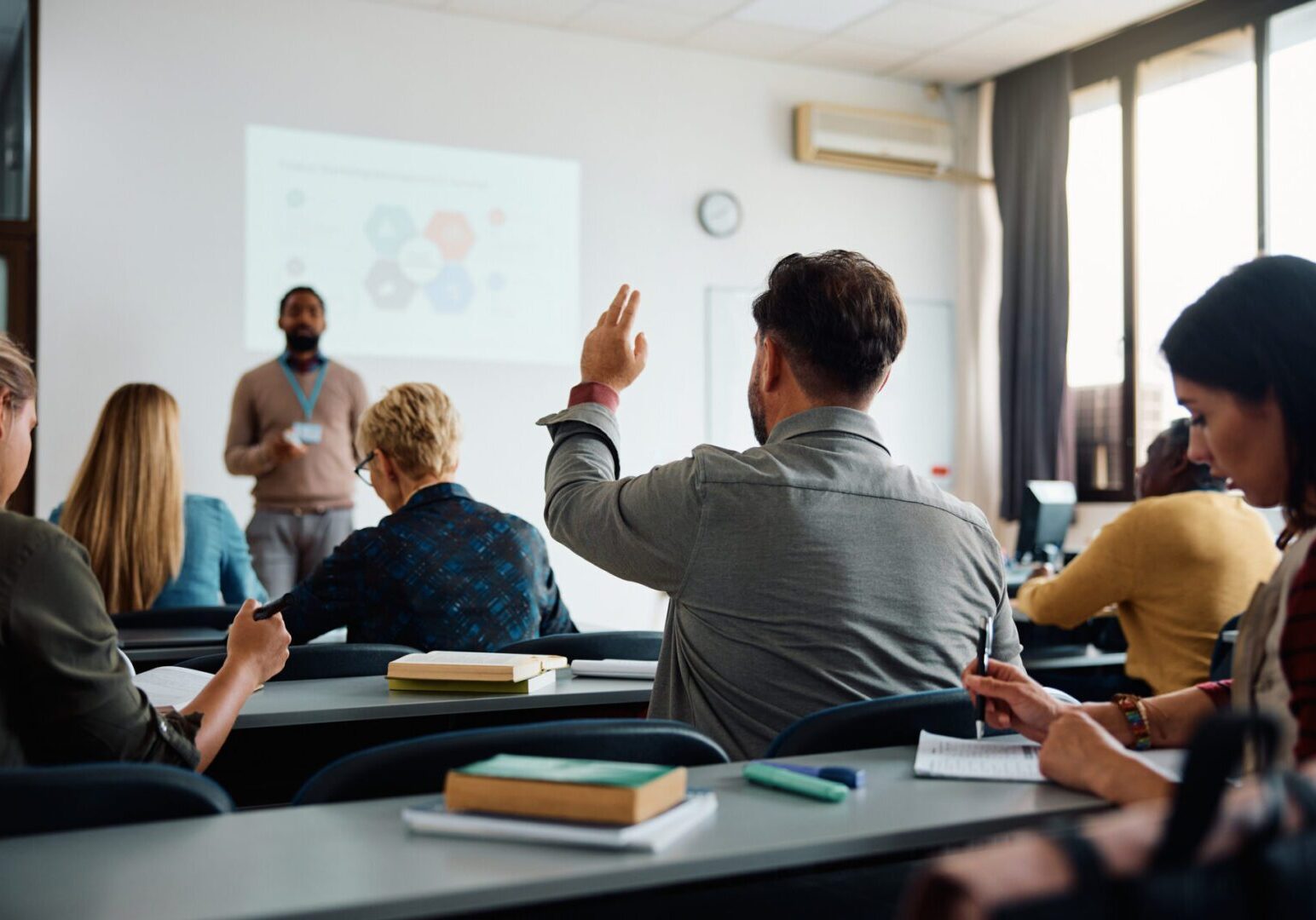 Student raising hand in lecture